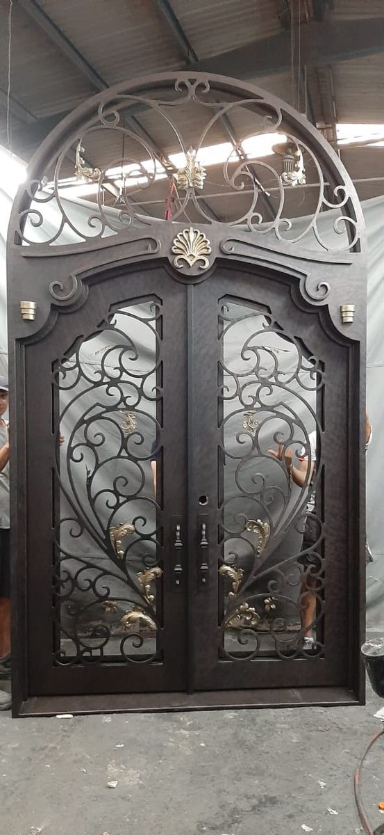 Wrought iron double door with arched scroll transom and gold accents