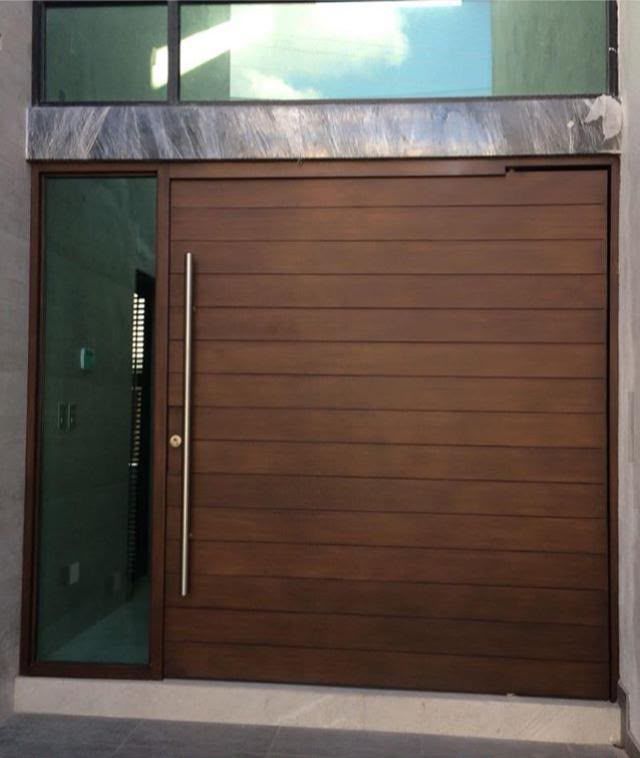 Modern wood-finish pivot entry door with stainless pull bar and glass sidelight